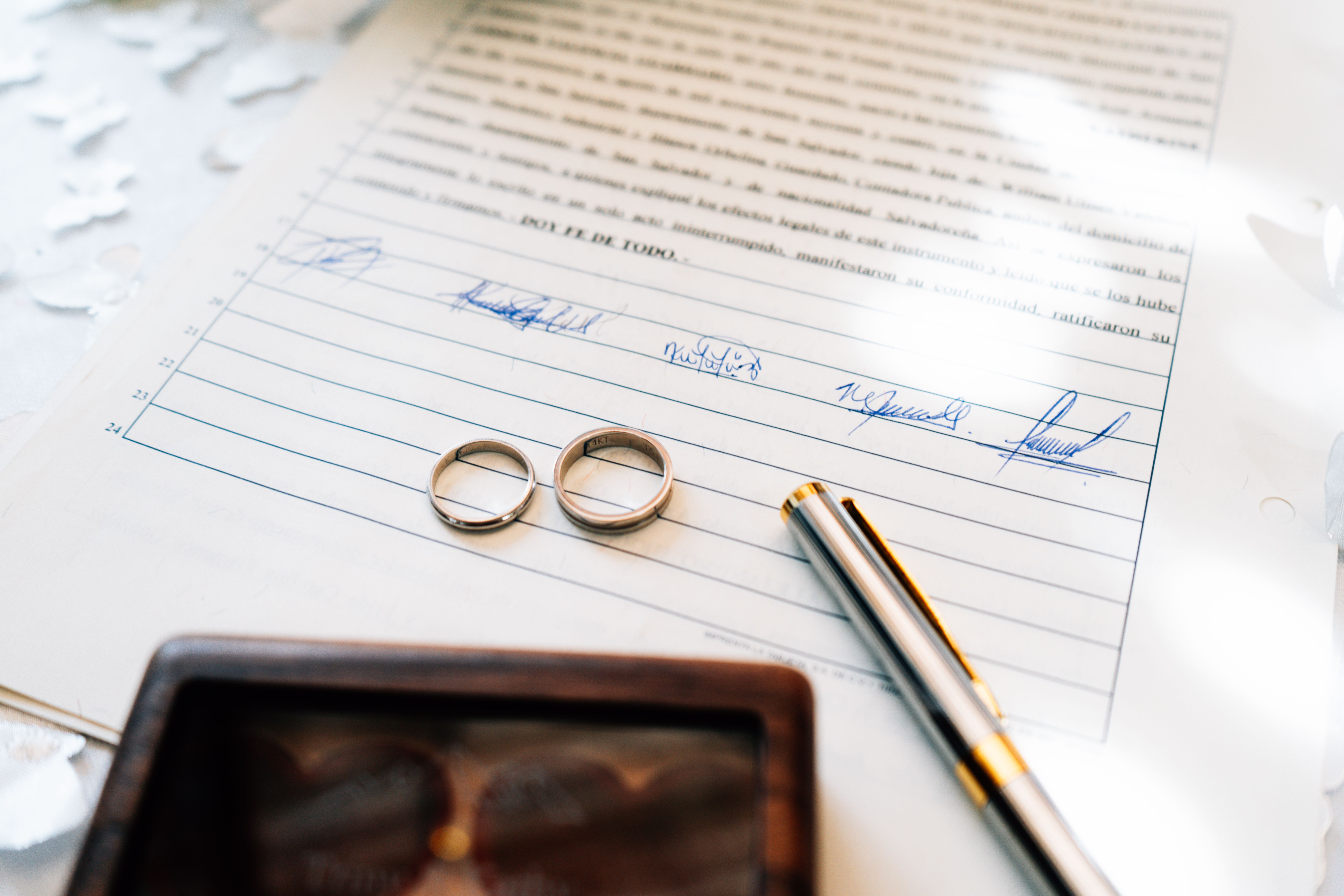 Alliances posées sur un acte de mariage signé, symbole du congé de mariage au Maroc